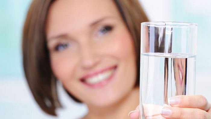 Woman holds glass of clean water